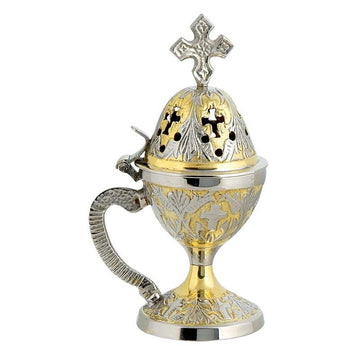 A two-toned (gold and silver) carved Thimiato - incense burner with a cross on top and decorative elements.