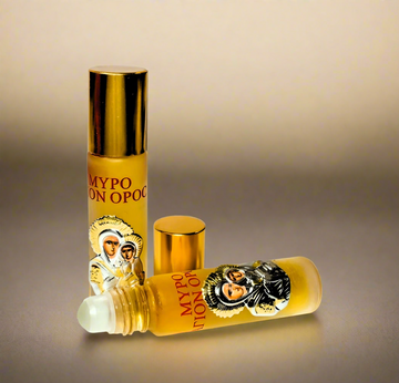 A roll-on glass bottle of Myrrh Anointing Oil with a decorative metal icon of the Virgin Mary, both the cap and the bottle displaying the sacred image.