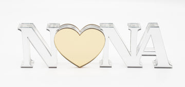 A personalized acrylic plaque with the name 'Nona' cut out in the shape of a heart, with a mirror like finish.