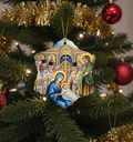 Decorative Christmas ornament with religious scene on a Christmas tree.