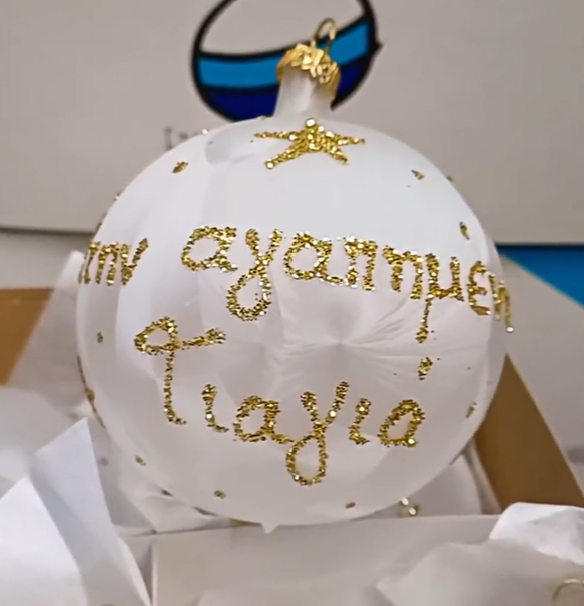 Hand blown glass bauble with gold accents and Greek text, displayed in a box with ribbon.