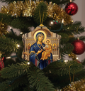 Decorative Christmas ornament of a religious scene on a Christmas tree with tinsel and lights.