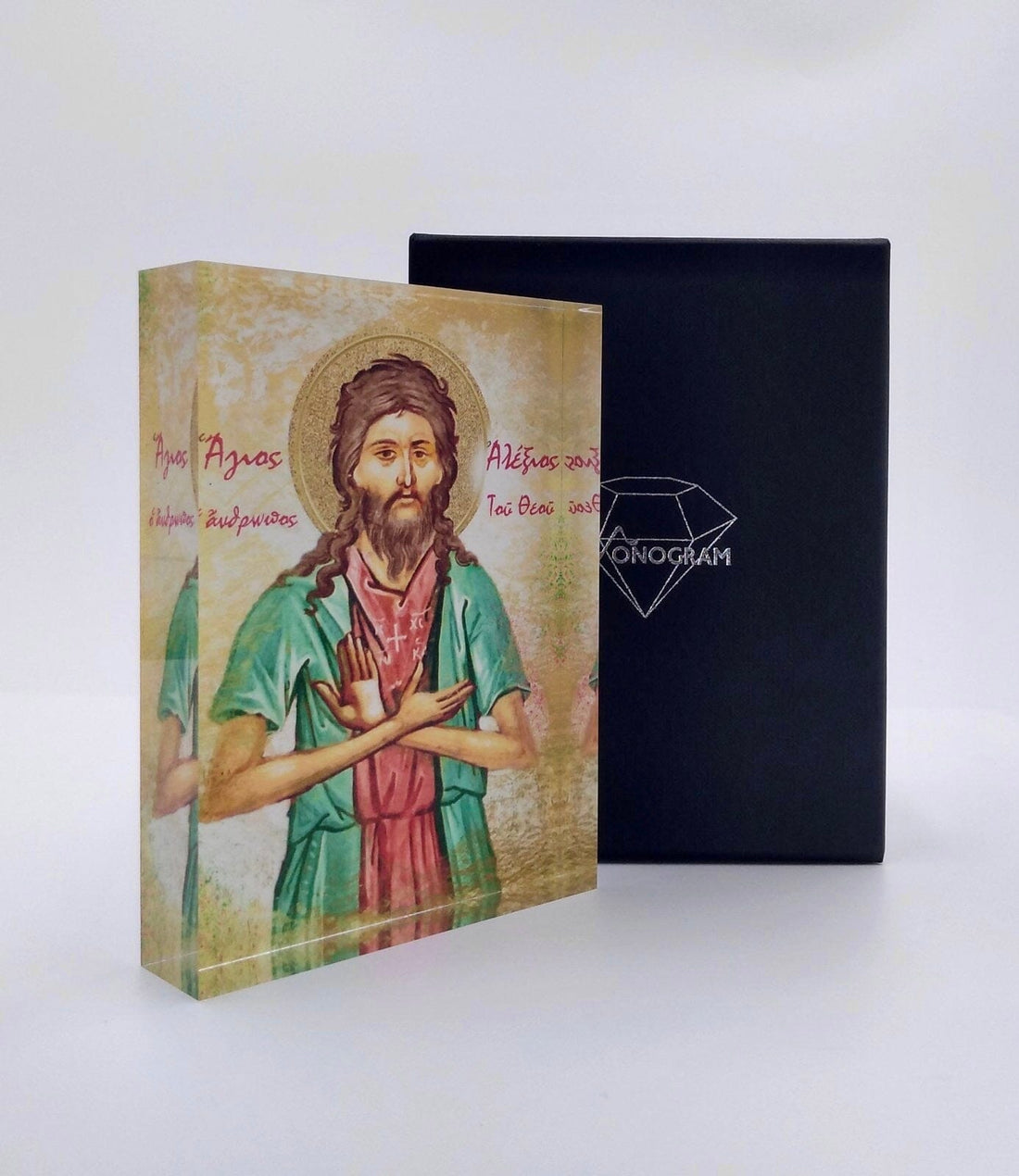 An icon of Saint Alexios, depicted in a vibrant color scheme, placed in a black case with a diamond-shaped logo on the front.
