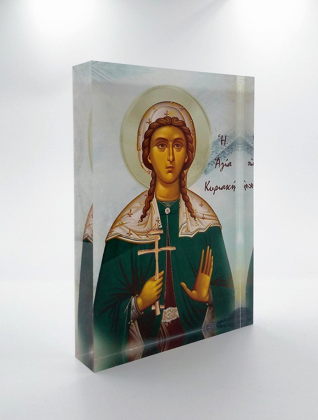 An icon of Saint Kiriaki with a 3D effect, displayed on a stand, with a black background and a diamond-shaped logo on the right side.