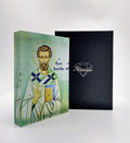 A handcrafted icon depicting Saint Leonidas, with a 3D effect, presented in front of a black background. The icon is housed in a black box with a clear display front, branded with 'Nostalgia'.
