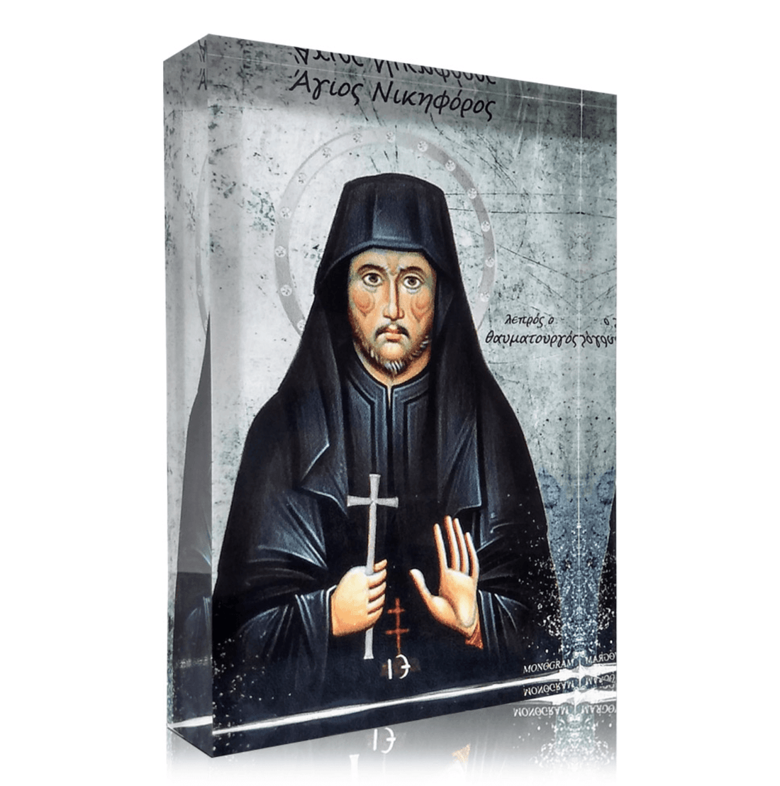 A plexiglass icon of Saint Nikiphoros, featuring a painted image of a monk in black robes holding a cross, with Greek text above and below the depiction.