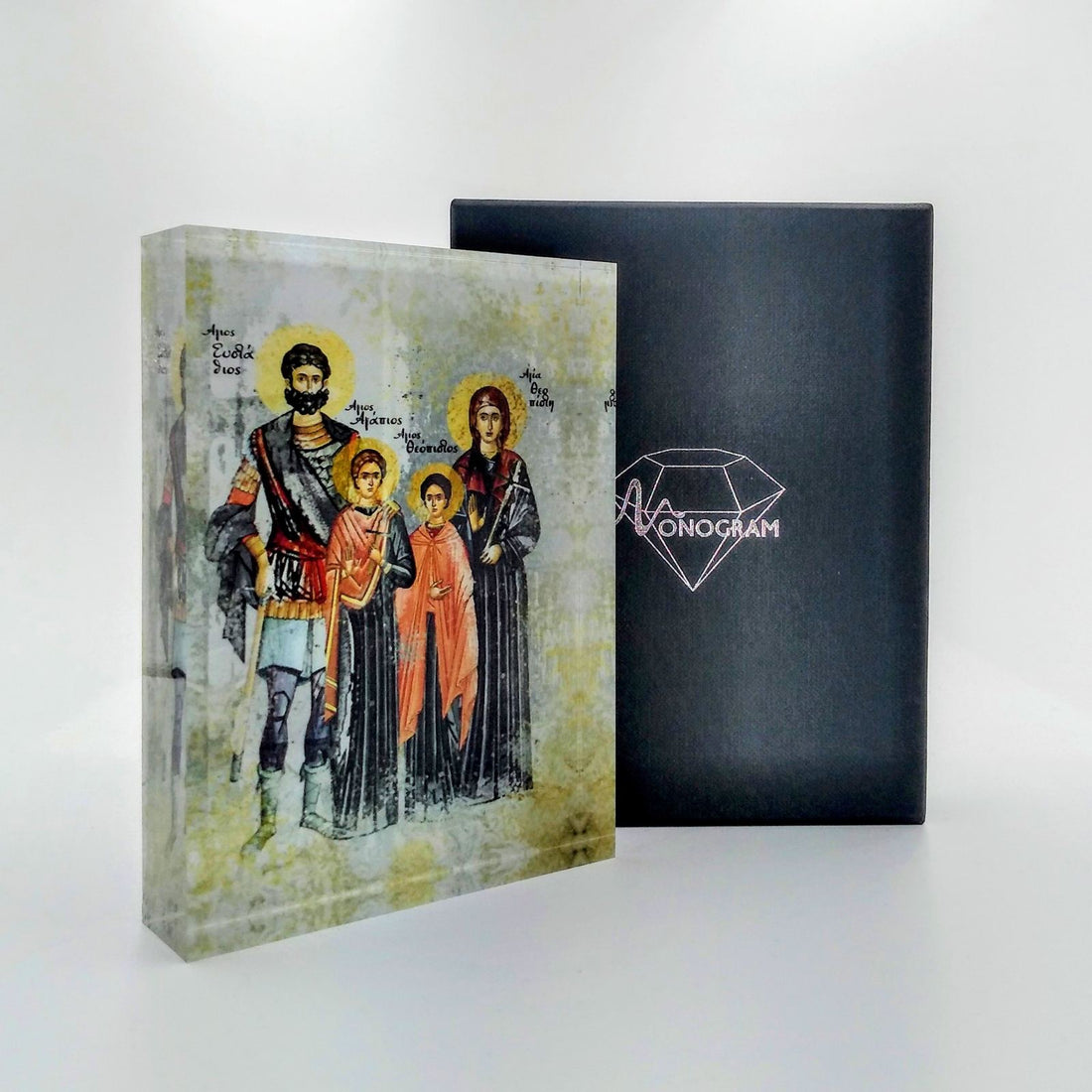 An icon depicting Saint Efstathios and his Holy Family, with a 3D effect, placed in a black case with a diamond-shaped logo on the cover.