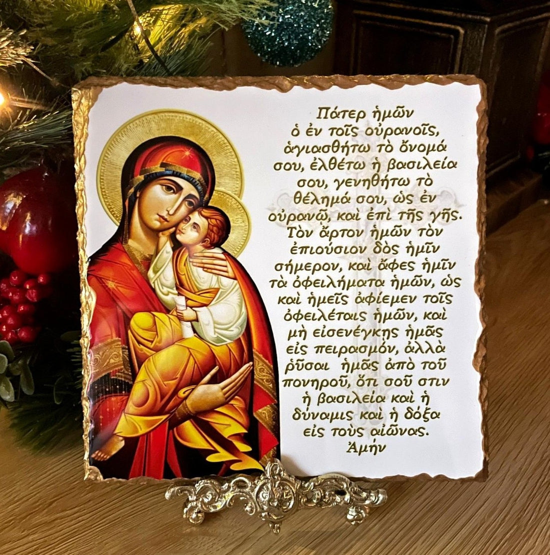 Orthodox icon of Panayia holding Christ. Handmade slate Greek icon featuring the Lord’s Prayer in Greek displayed on a brass stand.