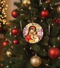 Decorative Christmas ornament of a religious scene on a Christmas tree with red and gold ornaments.