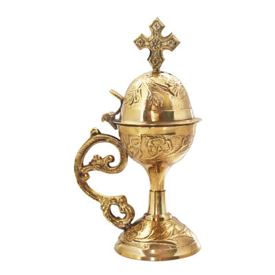 Gold censer with cross on top against a white background