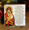 Orthodox icon of Panayia holding Christ. Handmade slate Greek icon featuring the Lord’s Prayer in Greek displayed on a brass stand.
