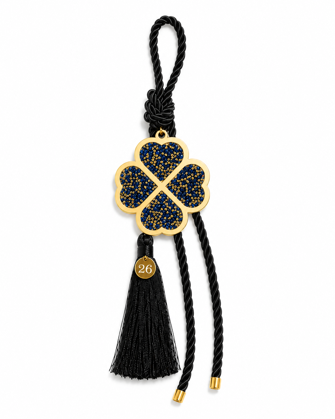 Four leaf clover lucky charm gouri with gold blue rhinestones, black cord, tassel and small tag.