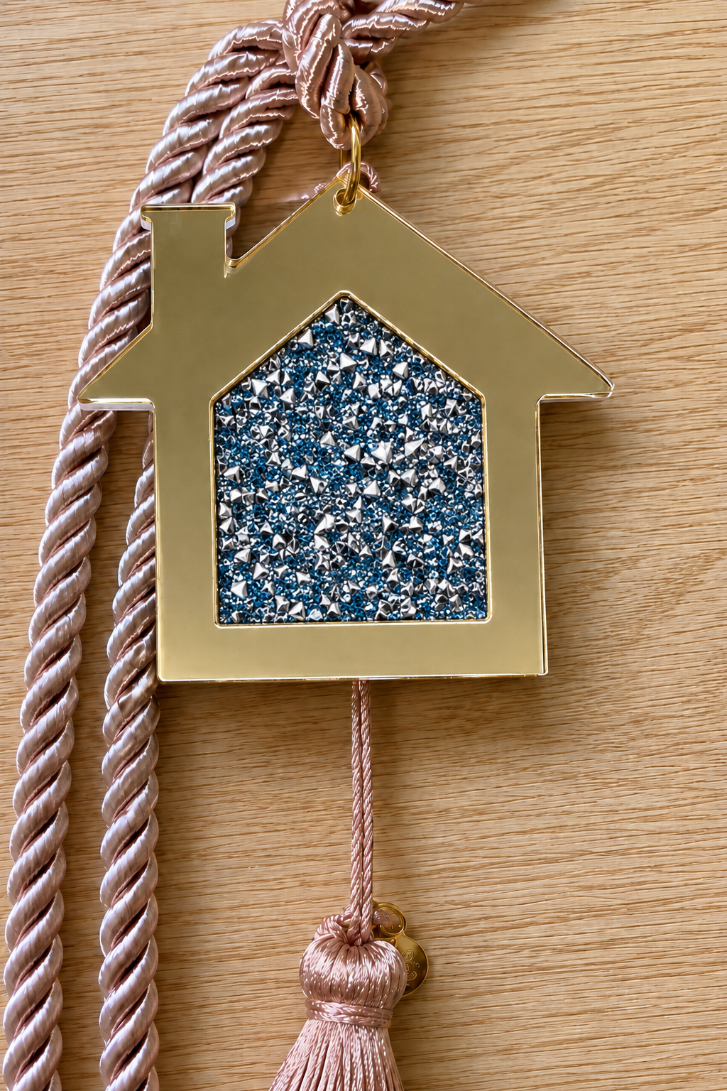 Gold acrylic house gouri lucky charm with blue and silver rhinestones and white cord