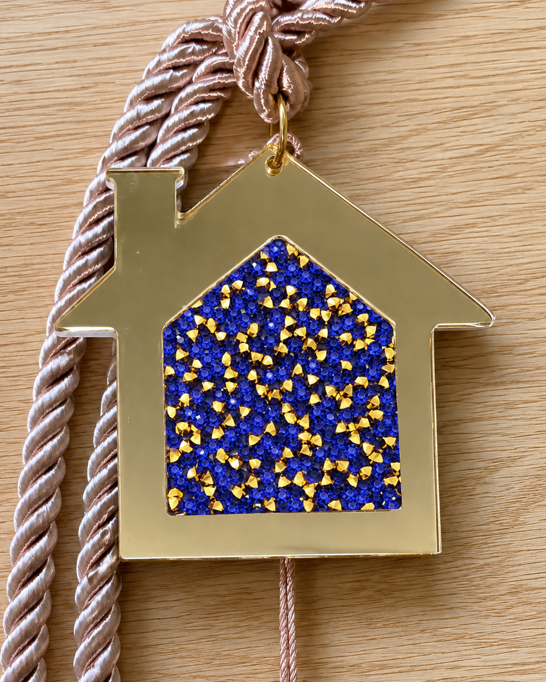 Gold acrylic house gouri lucky charm with blue and gold resin rhinestones and mocha cord