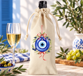 Natural linen wine bottle gift bag with Greek evil eye ornament, olive branches and red ribbon.