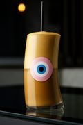 Glass of layered drink with a pink evil.