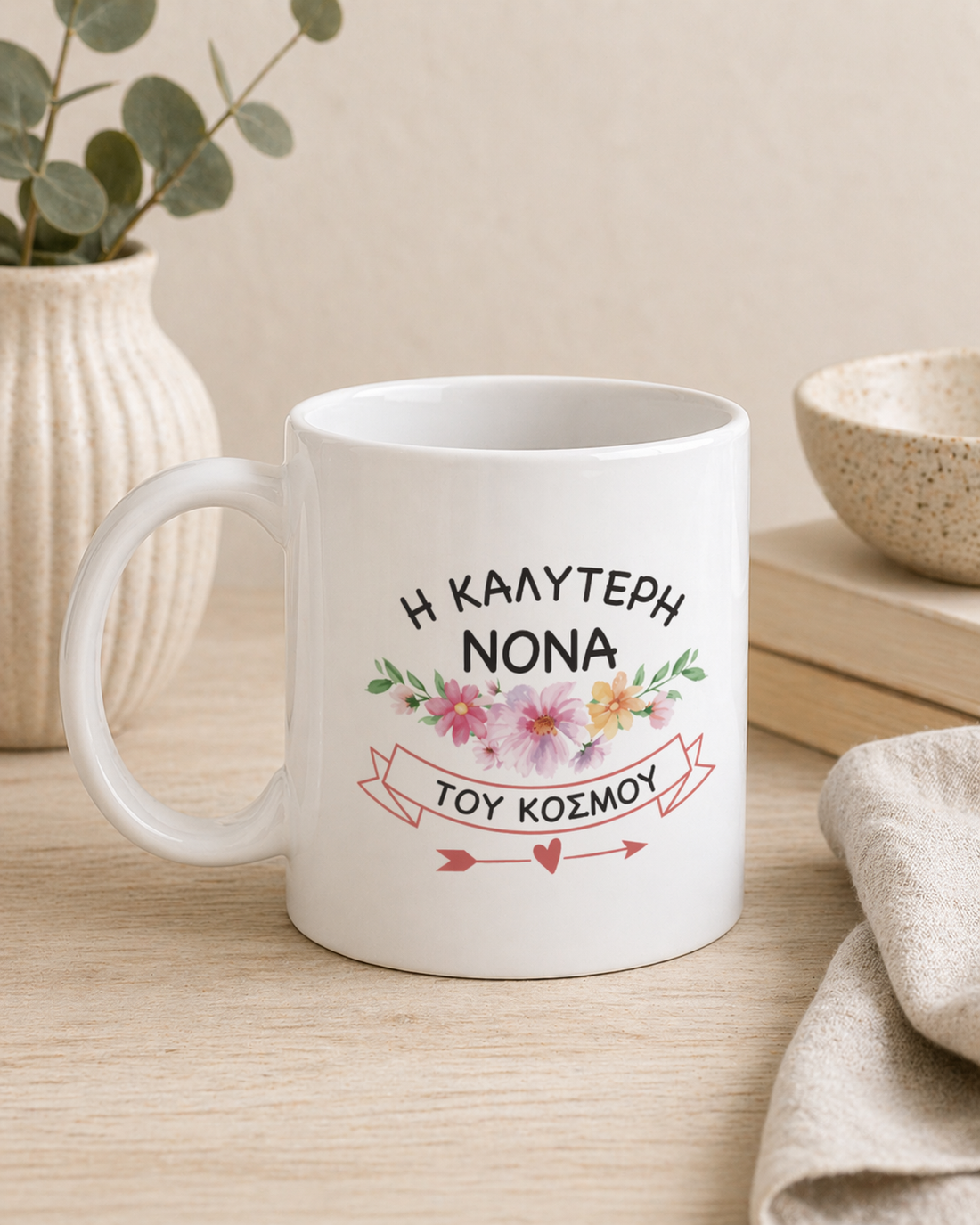 White ceramic mug with Greek text for Best Nona in the World and floral design. Gift mug for Greek godmother.