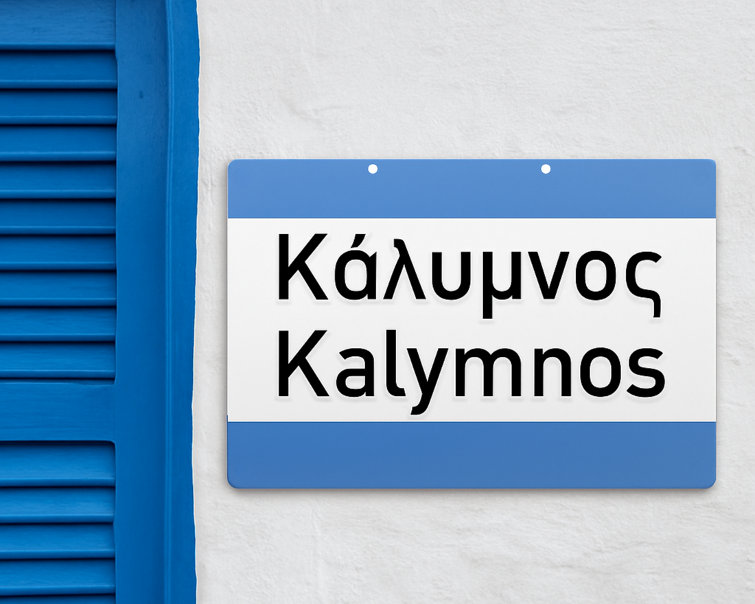 Aluminium Greek street arrow sign mounted on a whitewashed wall, Greek island style.

