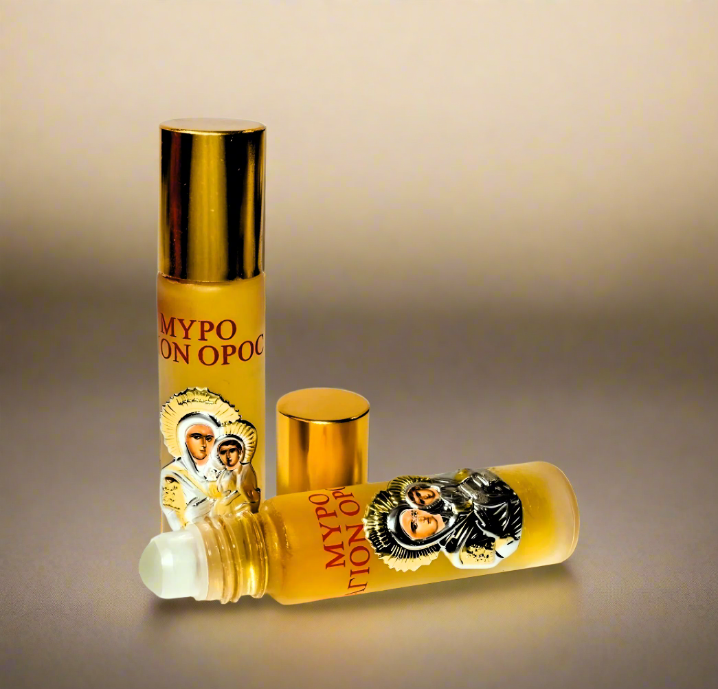 A roll-on glass bottle of Myrrh Anointing Oil with a decorative metal icon of the Virgin Mary, both the cap and the bottle displaying the sacred image.