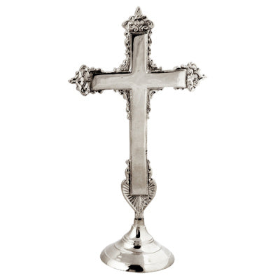 An ornate brass cross with a gold or silver finish, featuring intricate details and a prominent central crucifix.