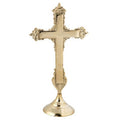 An ornate brass cross with a gold or silver finish, featuring intricate details and a prominent central crucifix.