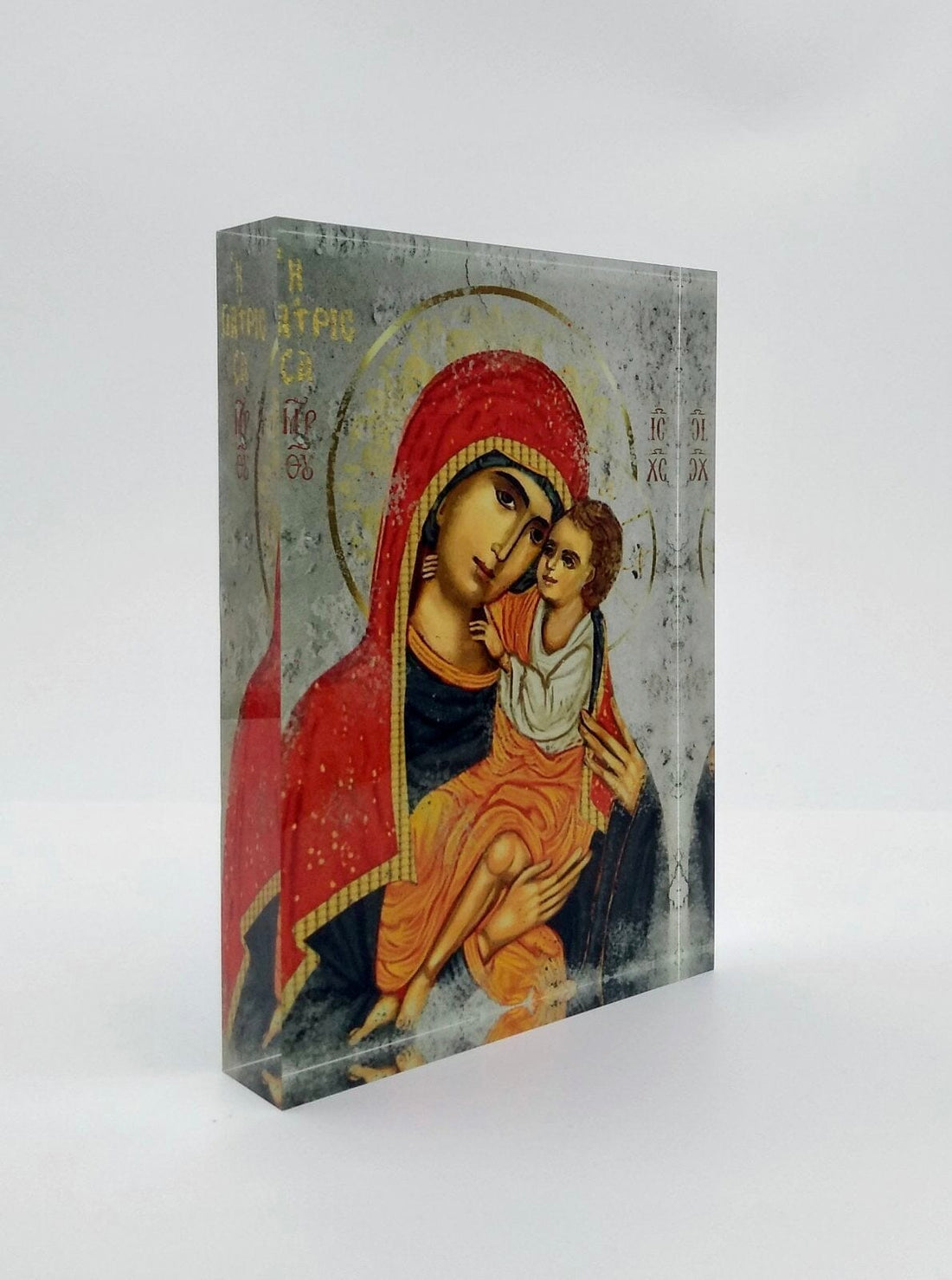Orthodox plexiglass icon of Panayia Giatrissa embracing Christ, displayed with Monogram Atelier gift box. Handmade Greek icon in soft gold and red tones.