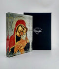 Orthodox plexiglass icon of Panayia Giatrissa embracing Christ, displayed with Monogram Atelier gift box. Handmade Greek icon in soft gold and red tones.