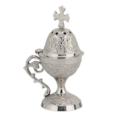 Silver incense burner with intricate designs and a cross on a white background