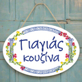 Decorative plate with floral design and Greek text on a gray background