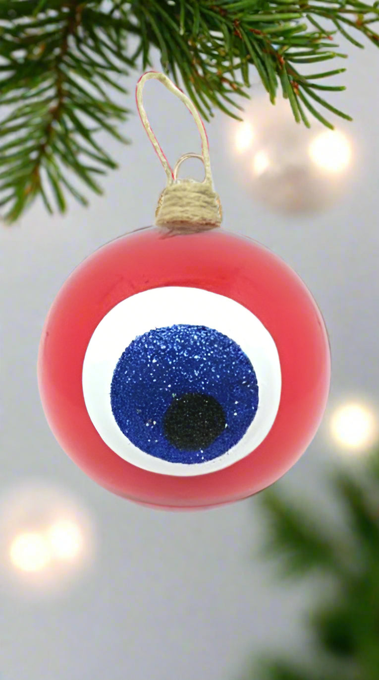 A red hand blown glass bauble with an evil eye