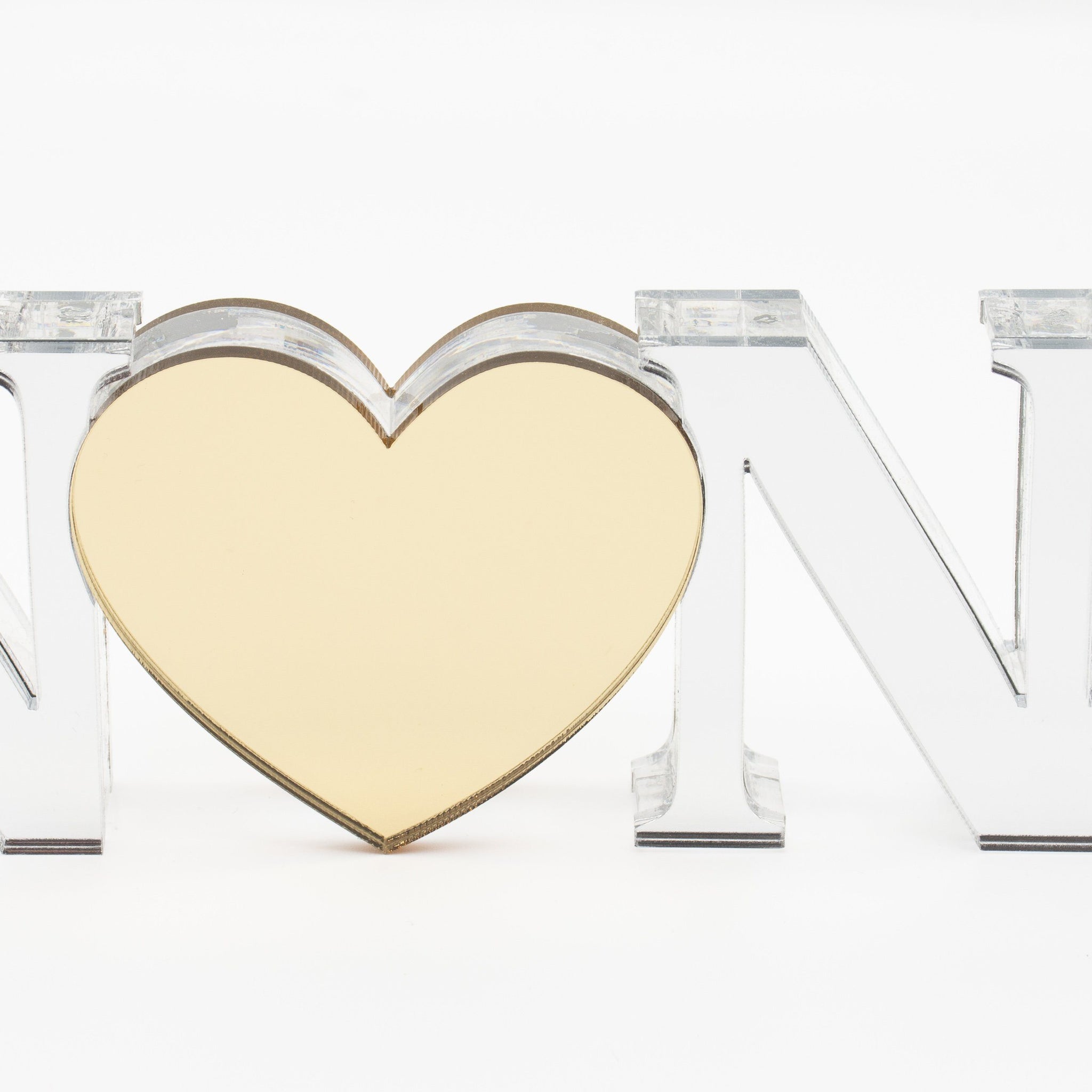 A personalized acrylic plaque with the name 'Nona' cut out in the shape of a heart, with a mirror like finish.