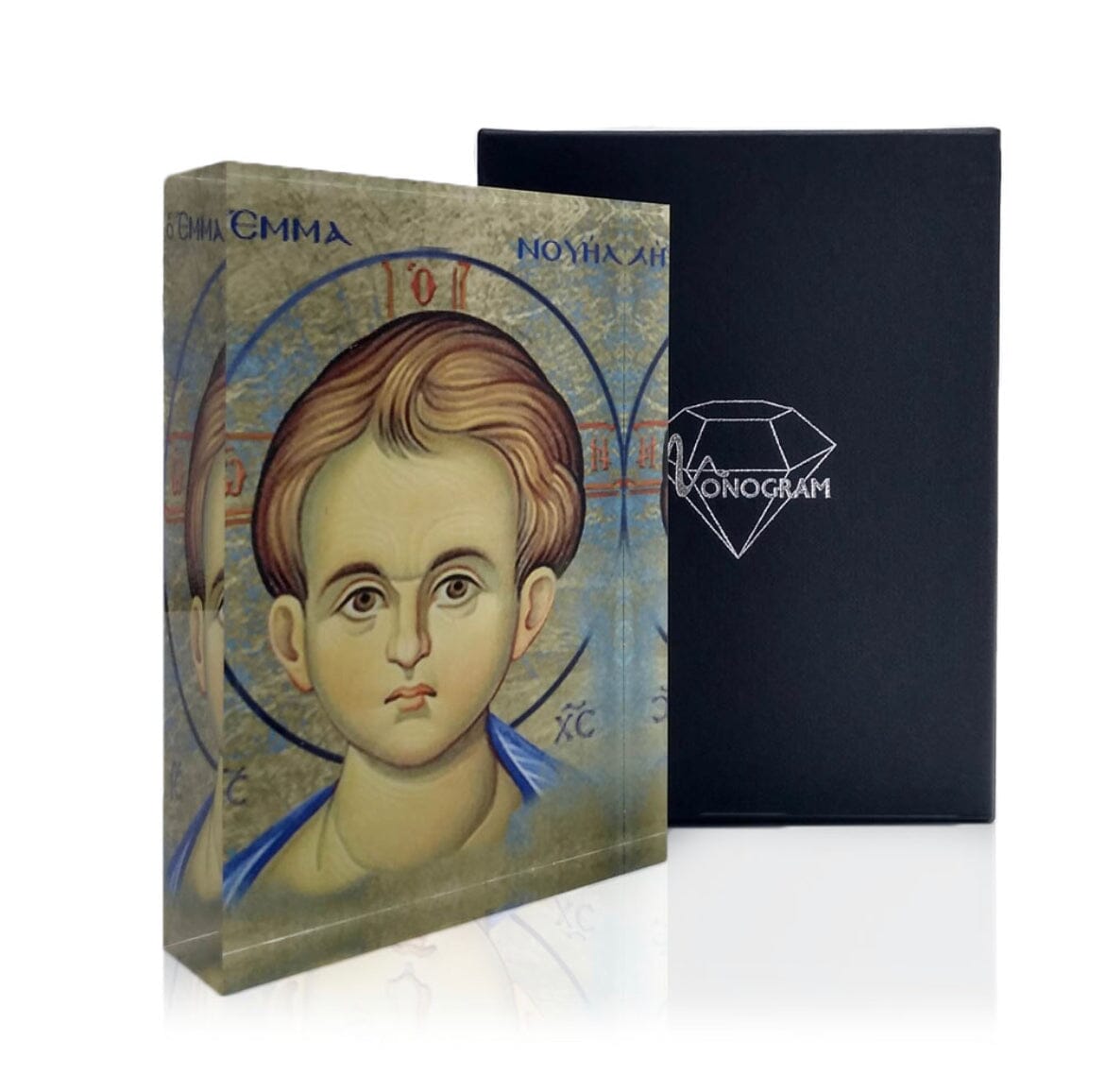 An icon depicting the face of Jesus Christ, with a 3D effect, alongside a black book with a diamond-shaped logo on the cover, all part of the Monogram Atelier collection.