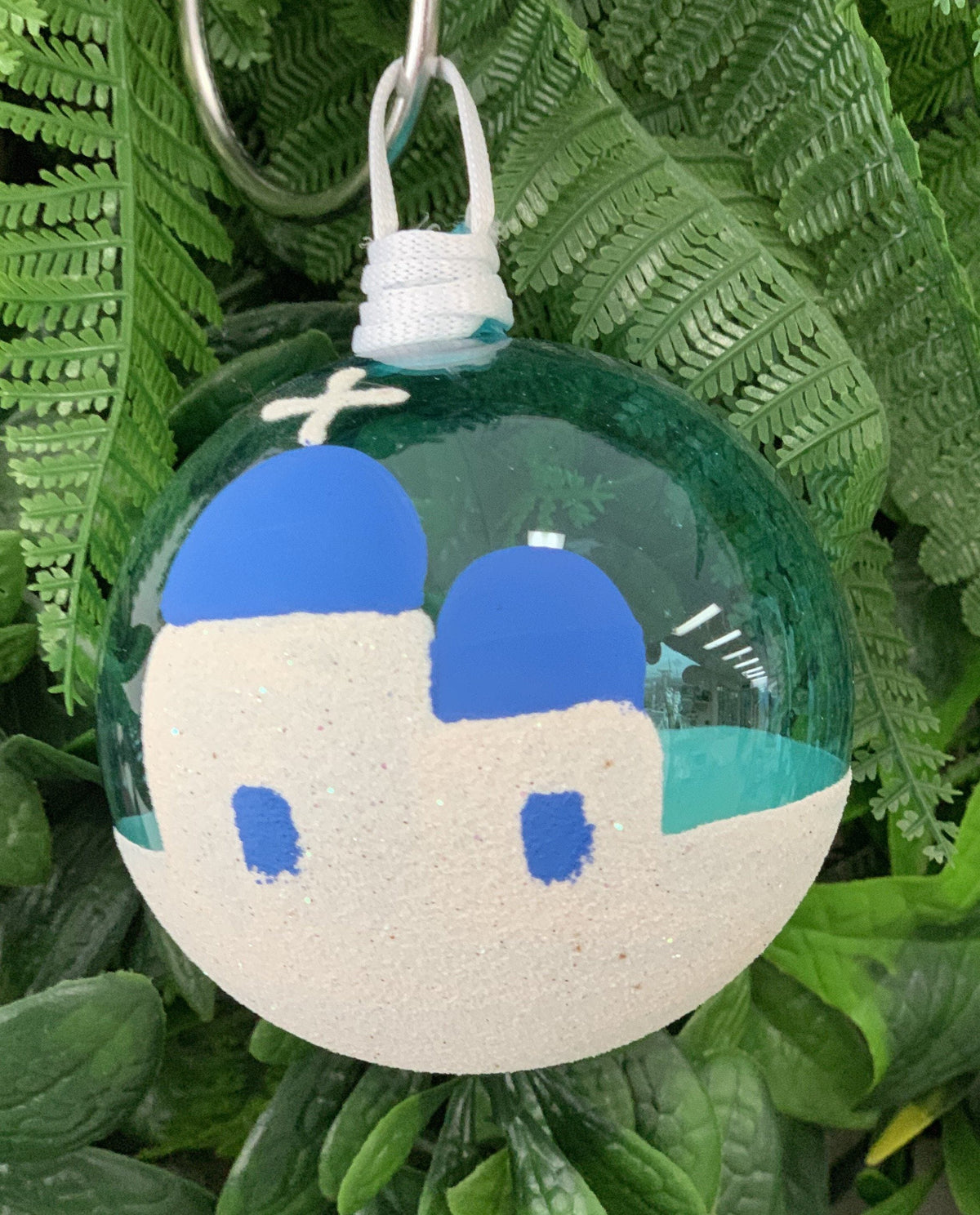 Teal blue Santorini Greek glass Christmas bauble with white church and blue dome design, handmade in Greece